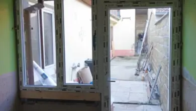 Nově nainstalované plastové dveře na balkóně ve staveništním prostředí.