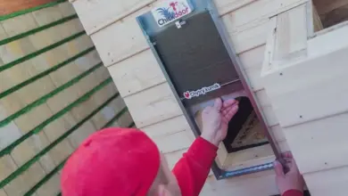 Instalace dveří do kurníku během stavby z pěnových bloků.