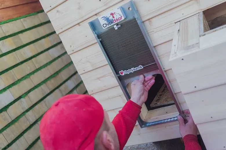 Instalace dveří do kurníku během stavby z pěnových bloků.