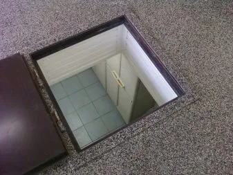 Otevřený poklop do suterénu ukazuje schodiště vedoucí dolů.