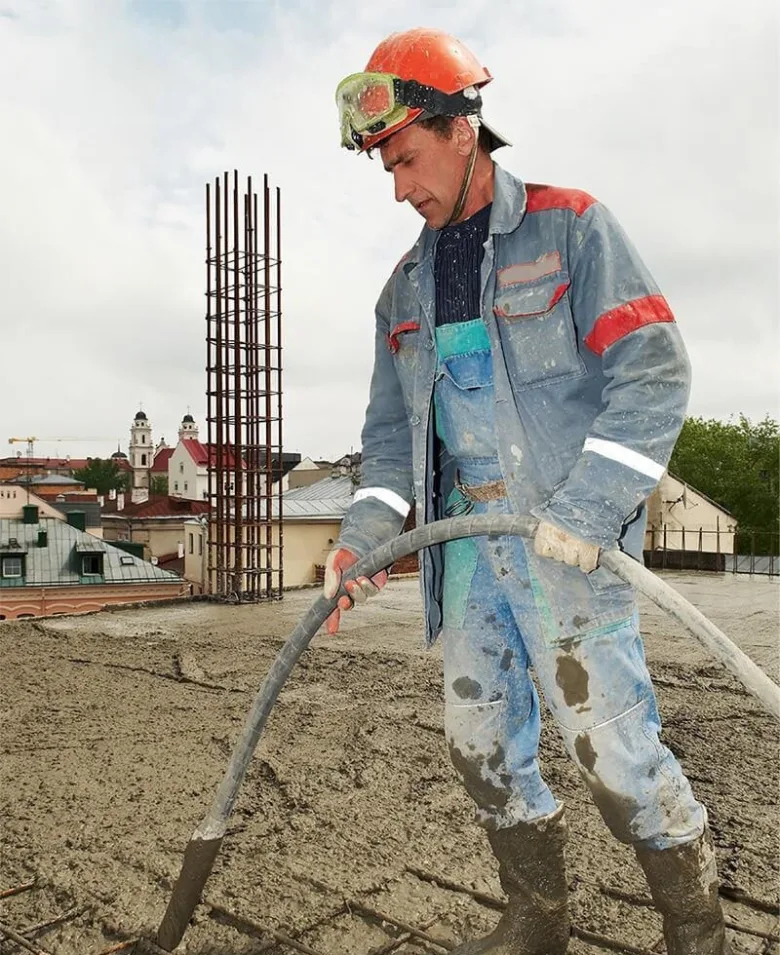 Stavebník nalévá beton na ocelovou výztuž.