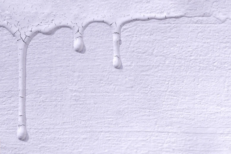 Bílá barva tekoucí po povrchu polystyrenové izolace.