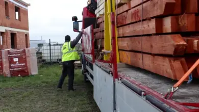 Dělník připevňuje dřevěné krokve k nákladnímu kamionu.