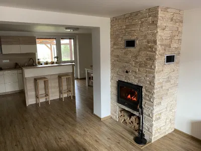Moderní kamenný krb s úložnou prostorem na dřevo.