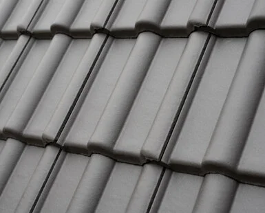 Blízko detail šedých tašek na střeše ukazuje jejich uspořádání.