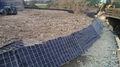 Černá geotextilie je položena na staveništi s těžkou technikou.