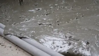 Čerstvý beton se rozlévá po povrchu s viditelnými bublinami.