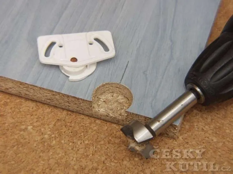 Vrták řezí sádrokarton při stavbě vestavěné skříni vlastními rukama.