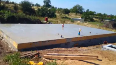 Stavební plocha s novou betonovou základnou na venkovském místě.