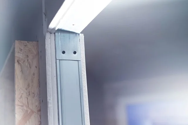 Detail sádrokartonové příčky ukazuje kovový profil na stěně.
