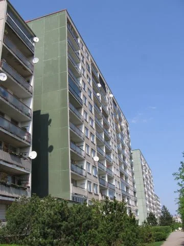 Fotografie fasády moderního panelového domu s balkony.