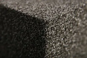 Detailní záběr na texturu tmavě šedého pěnového izolačního materiálu.