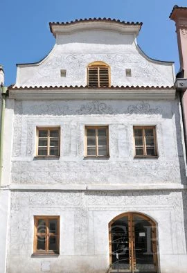 Historická budova se vykrabovanými vzory na fasádě technikou sgrafit.