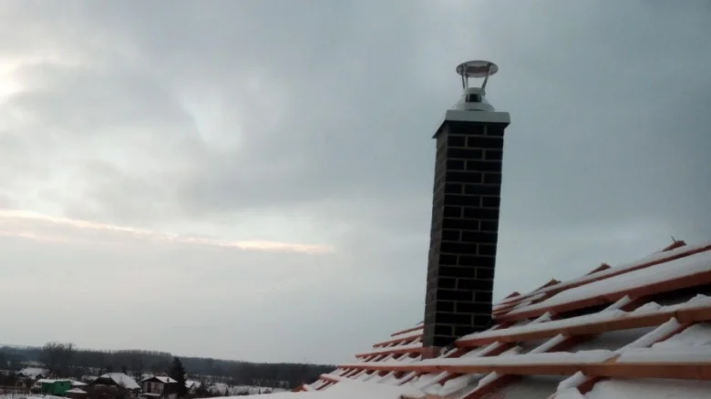 Hotový komín na sněhové střechě ukazuje výsledek stavby.