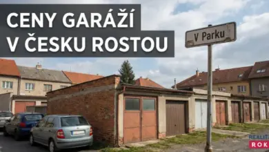 Řada garáží v českoměstské zástavbě s parkovanými auty.