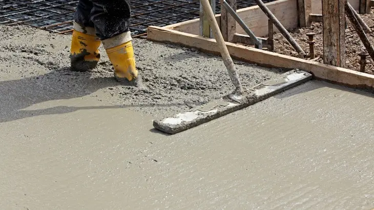 Práce s čerstvým betonem na vyztužené podlahové desce.