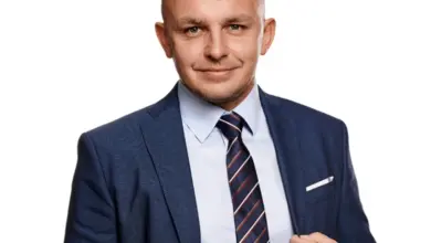 Profesionální portrét muže v obleku s kravatou na bílém pozadí.