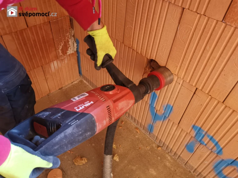 Práce s elektrickým řezačem pro drážky ve zdi při pokládání kabeláže.