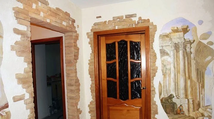 Dveře s kamenným rámem v interiéru panelového domu po úpravě.