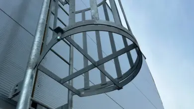 Konstrukce požárního žebříku s kovovými stupni připevněná k budově.