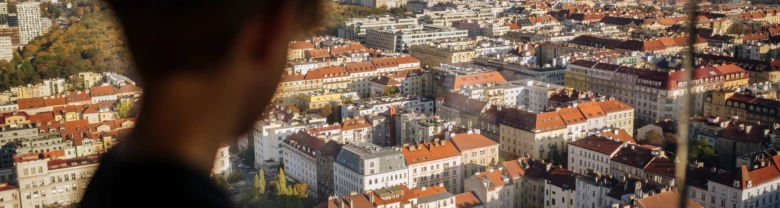 Pohled na město s červenými střechami z okna.