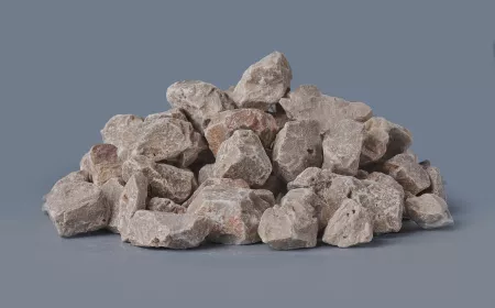 Hromada hrubých kusů vápence na neutrálním pozadí.