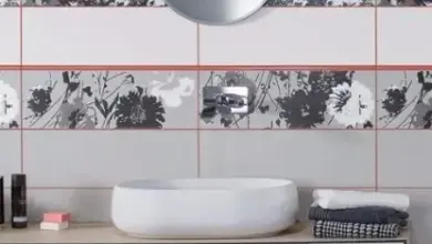 Bílé obklady v koupelně s tmavou spárovací hmotou.