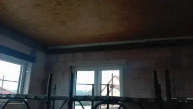 Neukončený strop z desek OSB s nosnou konstrukcí v interiéru.