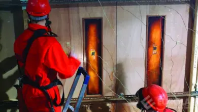 Zkušební hořlavost dřevěného materiálu s pracovníky v ochranném obleku.