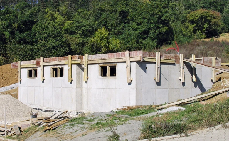 Základová deska domu v fázi stavby s dřevěnými oporami.