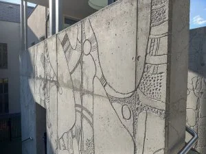 Fotografie zdi se sgrafitovými kresbami na fasádě budovy.