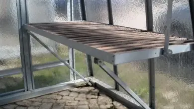 Dřevěná podlaha pro průchod ve skleníku s kovovým rámem.