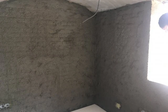Nanosená hydroizolační vrstva na vnitřní betonové stěny ve koutu.