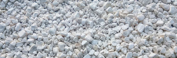Bílý rozbitý kámen vápence na zemi.