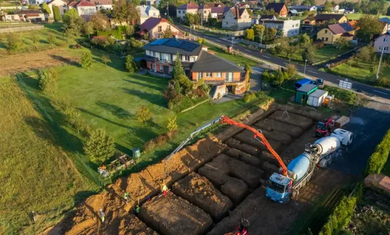 Stavební práce na přístavbě domu s vykopanými základy.