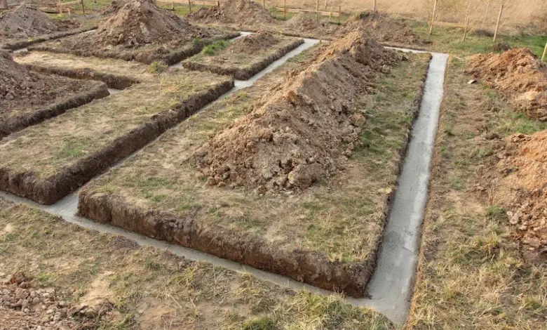 Základové příkopy s čerstvou betonovou deskou pro stavbu domu.