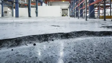 Poškozená betonová podlaha v průmyslovém skladu připravená na opravu.