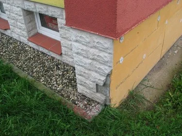 Detail domu ukazující výšku soklu nad štěrkem.