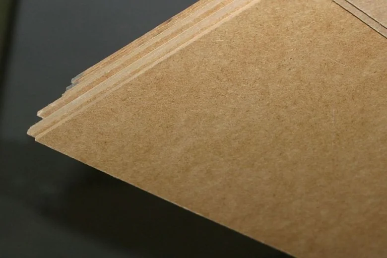 Blízký záběr na hrany vrstvené desky z MDF s viditelnou texturou.