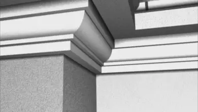 Detail střešní římsy s okapem na rohu fasády domu.