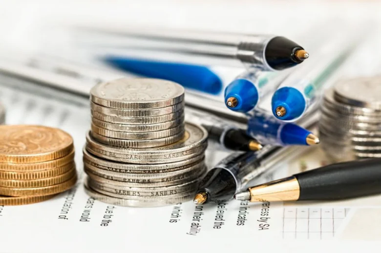 Mince a pero na dokumentech symbolizují finance pro výstavbu garáže.