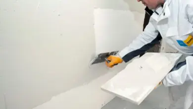 Pracovník omítá zdivo špachtlí na stěnu.