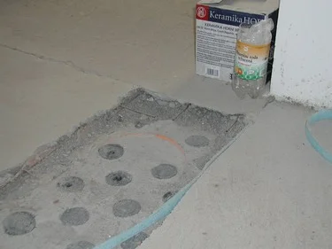 Betonová podlahová mazanina s otvory pro instalaci podle norem.