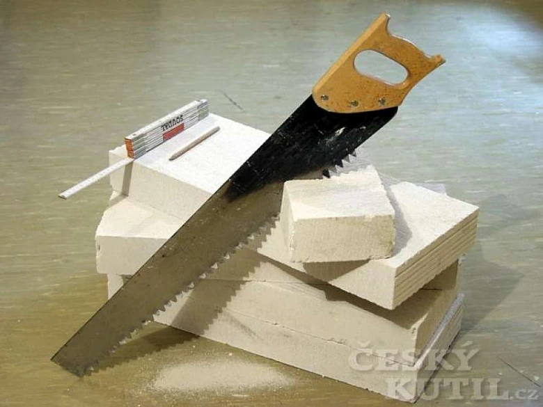 Ruční pila řezá bílé bloky z plynostykového betonu.