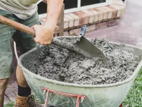 Míchání betonu v vozíku pomocí lopaty.
