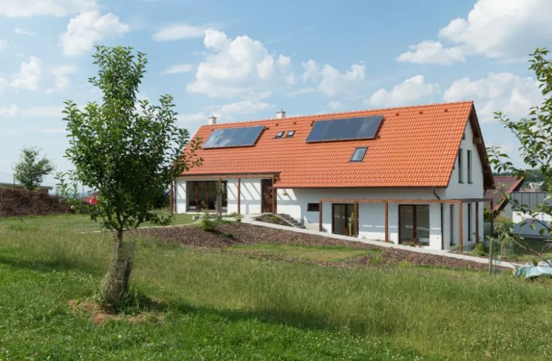 Moderní dům na svahu s fotovoltaickými panely.