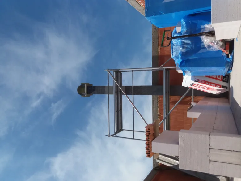 Instalace komína z nerezové oceli na budově s lešení.