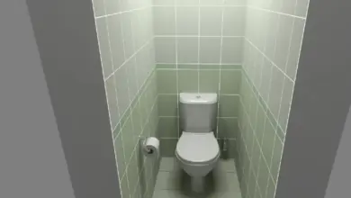 Malá toaleta s zelenými dlaždicemi v úzkém prostoru.