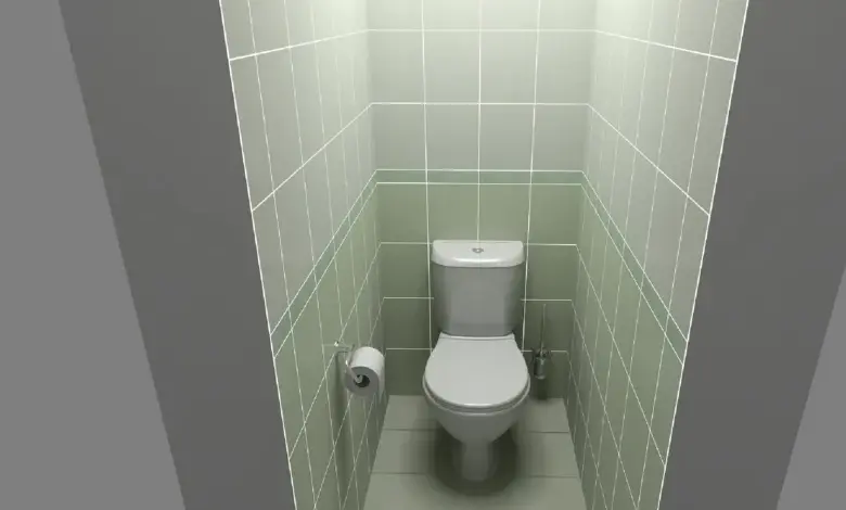 Malá toaleta s zelenými dlaždicemi v úzkém prostoru.