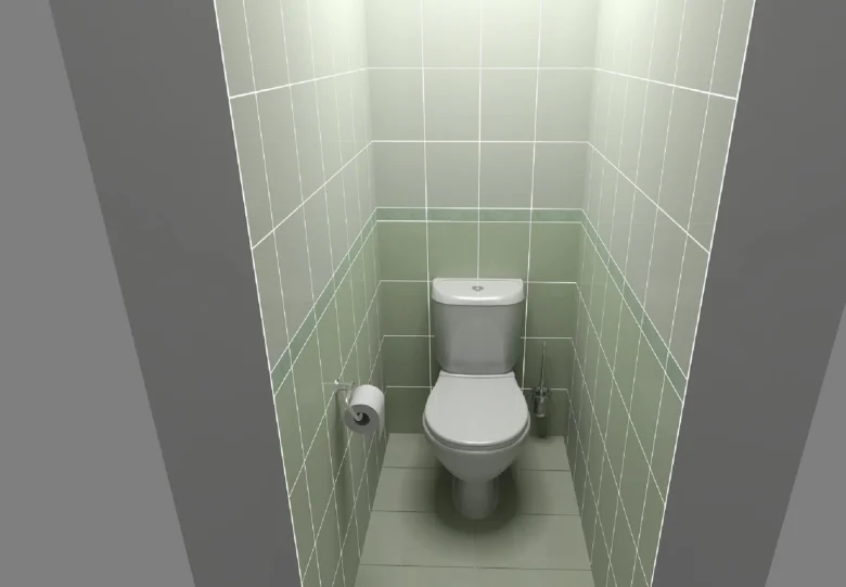 Malá toaleta s zelenými dlaždicemi v úzkém prostoru.
